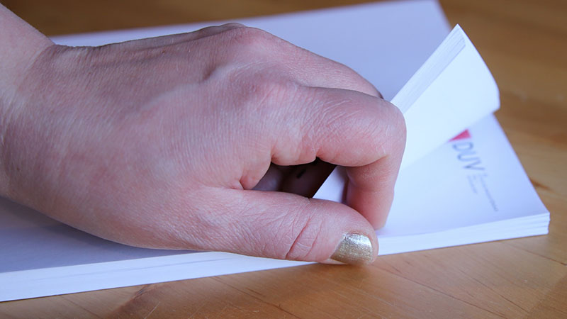hand som bläddrar bland papper