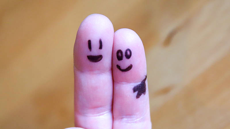 Glada ansikten målade på fingrar placerade bredvid varandra som vänner